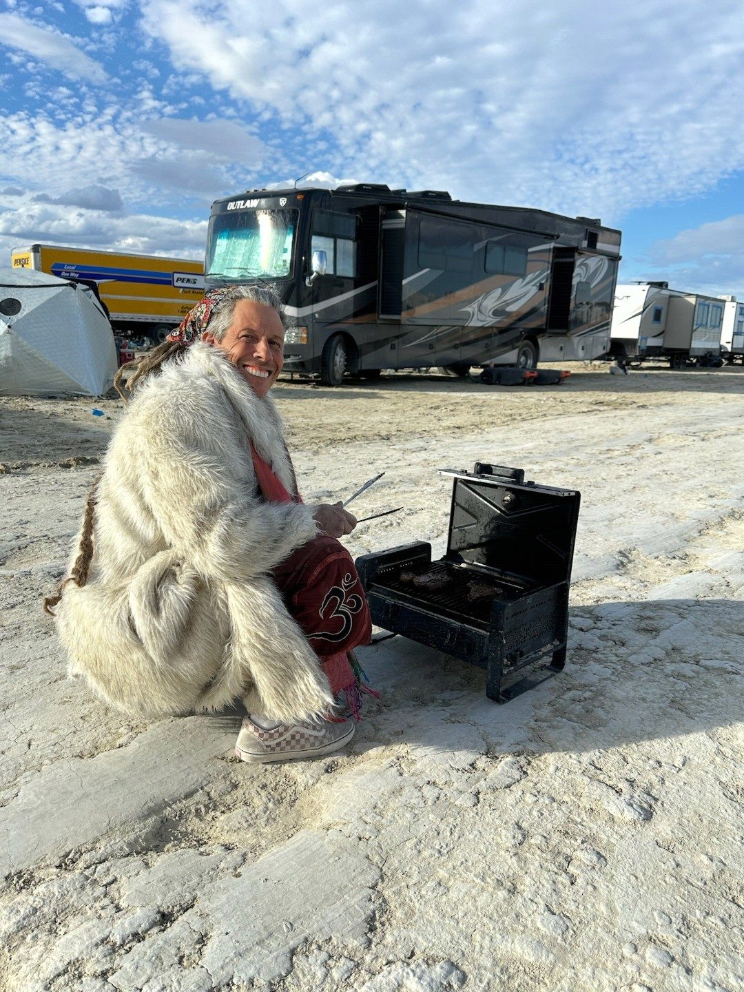 Jim sitting outside an RV at a desert festival camp